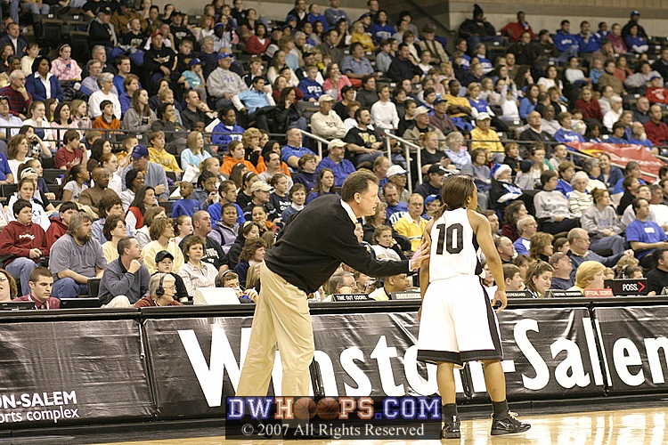 Head Coach Mike Peterson works with Tiffany Roulhac, with backdrop of a large Duke contingent