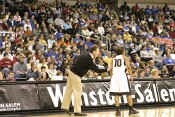 Head Coach Mike Peterson works with Tiffany Roulhac, with backdrop of a large Duke contingent