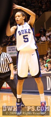Jasmine Thomas nails a three pointer, as I try to peer around the ref's backside to get the shot -  - D5;1, 1:36, 28-11