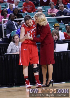 NC State Head Coach Kellie Harper assists Emili Tasler, who fell face-first into the press table going for a loose ball. -  - 