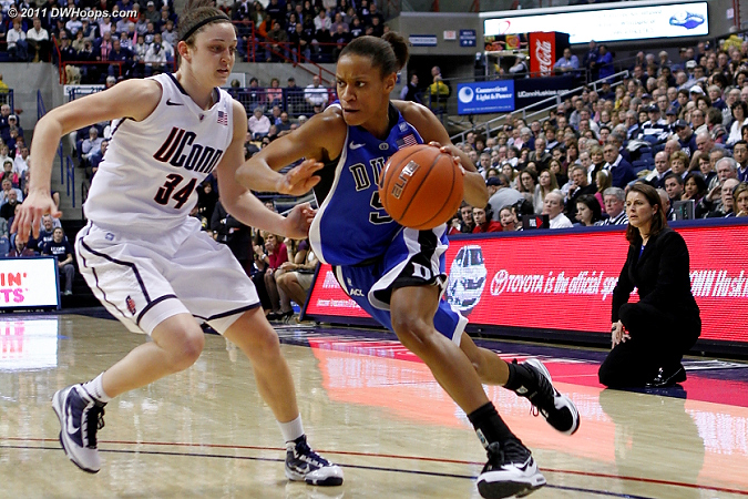 Jas drives on Kelly Faris as Coach P looks on  - Duke Tags: #5 Jasmine Thomas 