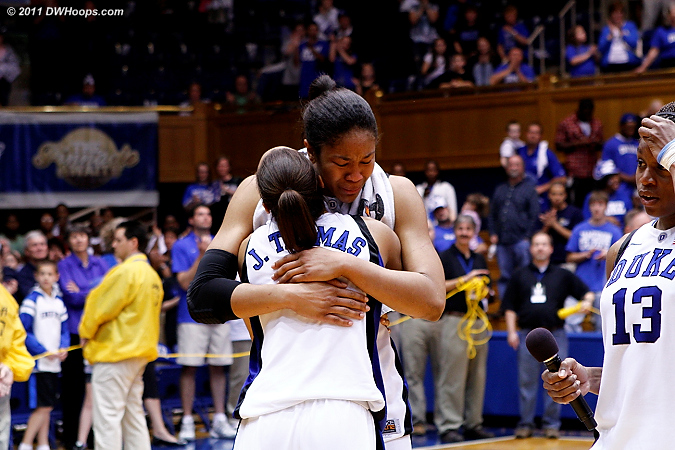 Karima takes the microphone from Krystal as the Thomases embrace  - Duke Tags: #5 Jasmine Thomas, #13 Karima Christmas, #34 Krystal Thomas 