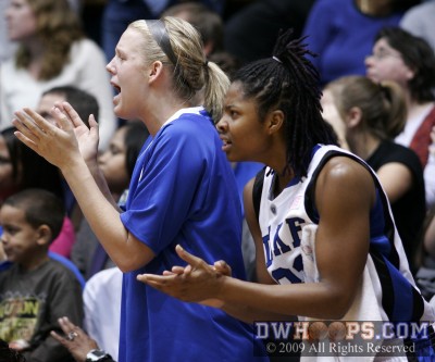 Kathleen Scheer and Keturah Jackson cheer on the Blue Devils from the bench. -  - 